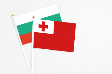 Tonga and Bulgaria stick flags on white background. High quality fabric, miniature national flag. Peaceful global concept.White floor for copy space.