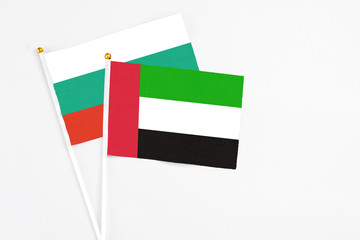 United Arab Emirates and Bulgaria stick flags on white background. High quality fabric, miniature national flag. Peaceful global concept.White floor for copy space.