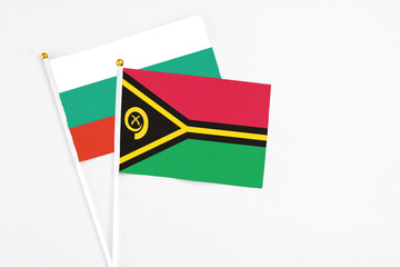 Vanuatu and Bulgaria stick flags on white background. High quality fabric, miniature national flag. Peaceful global concept.White floor for copy space.