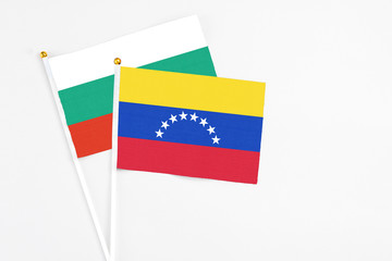 Venezuela and Bulgaria stick flags on white background. High quality fabric, miniature national flag. Peaceful global concept.White floor for copy space.
