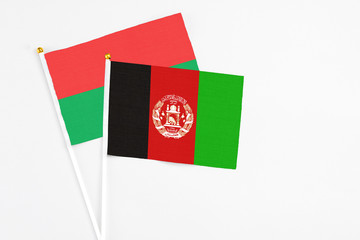 Afghanistan and Burkina Faso stick flags on white background. High quality fabric, miniature national flag. Peaceful global concept.White floor for copy space.