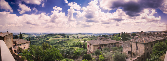Beautiful cumulus-clouded panorama from the top of the wall of the medieval tuscan town San Gimignano