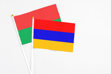 Armenia and Burkina Faso stick flags on white background. High quality fabric, miniature national flag. Peaceful global concept.White floor for copy space.