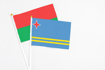 Aruba and Burkina Faso stick flags on white background. High quality fabric, miniature national flag. Peaceful global concept.White floor for copy space.