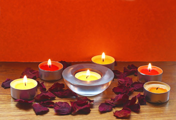 Fototapeta na wymiar spa background with burning candles and dried rose petals