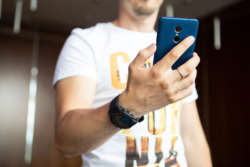 Man looking at scratched used smartphone indoor