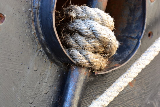 Large thick, strong, marine rope tied in a knot in marina