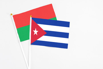 Cuba and Burkina Faso stick flags on white background. High quality fabric, miniature national flag. Peaceful global concept.White floor for copy space.