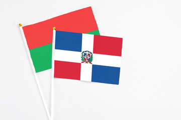 Dominican Republic and Burkina Faso stick flags on white background. High quality fabric, miniature national flag. Peaceful global concept.White floor for copy space.