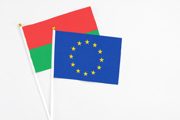 European Union and Burkina Faso stick flags on white background. High quality fabric, miniature national flag. Peaceful global concept.White floor for copy space.