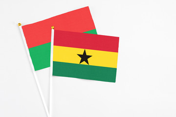 Ghana and Burkina Faso stick flags on white background. High quality fabric, miniature national flag. Peaceful global concept.White floor for copy space.