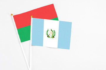 Guatemala and Burkina Faso stick flags on white background. High quality fabric, miniature national flag. Peaceful global concept.White floor for copy space.