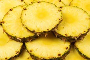 Pineapple juicy yellow slices background. Top view.
