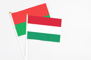 Hungary and Burkina Faso stick flags on white background. High quality fabric, miniature national flag. Peaceful global concept.White floor for copy space.