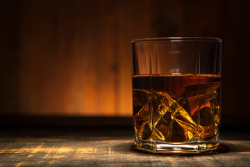 glass of whiskey on a wooden table in a bar