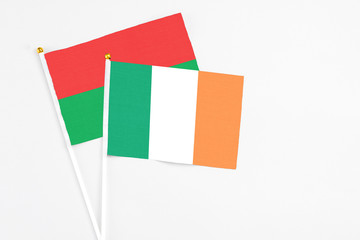 Ireland and Burkina Faso stick flags on white background. High quality fabric, miniature national flag. Peaceful global concept.White floor for copy space.