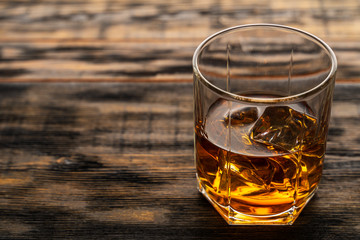 glass of whiskey on a wooden table in a bar