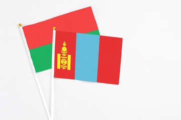 Naklejka premium Mongolia and Burkina Faso stick flags on white background. High quality fabric, miniature national flag. Peaceful global concept.White floor for copy space.