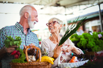 Portrait of beautiful elderly couple in market buing food