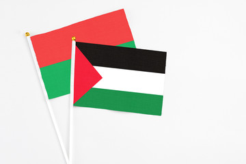 Palestine and Burkina Faso stick flags on white background. High quality fabric, miniature national flag. Peaceful global concept.White floor for copy space.