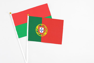 Portugal and Burkina Faso stick flags on white background. High quality fabric, miniature national flag. Peaceful global concept.White floor for copy space.