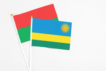Rwanda and Burkina Faso stick flags on white background. High quality fabric, miniature national flag. Peaceful global concept.White floor for copy space.