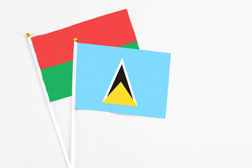 Saint Lucia and Burkina Faso stick flags on white background. High quality fabric, miniature national flag. Peaceful global concept.White floor for copy space.