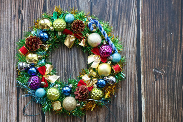 Colorful christmas wreath on dark wooden background, flat lay, horizontal