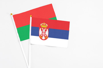 Serbia and Burkina Faso stick flags on white background. High quality fabric, miniature national flag. Peaceful global concept.White floor for copy space.