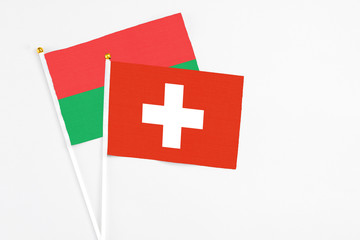 Switzerland and Burkina Faso stick flags on white background. High quality fabric, miniature national flag. Peaceful global concept.White floor for copy space.