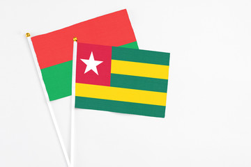 Togo and Burkina Faso stick flags on white background. High quality fabric, miniature national flag. Peaceful global concept.White floor for copy space.