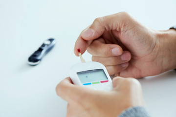 man measuring his blood glucose level