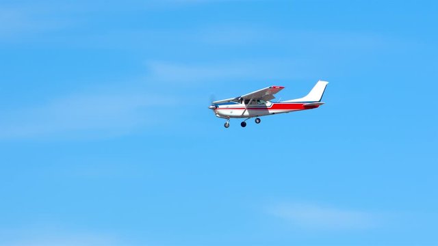 Generic Small Private Single Engine Airplane Flying in a Sunny Blue Sky with Thin White Clouds