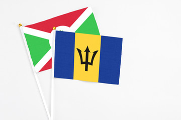 Barbados and Burundi stick flags on white background. High quality fabric, miniature national flag. Peaceful global concept.White floor for copy space.