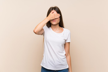 Pretty young girl over isolated background covering eyes by hands. Do not want to see something