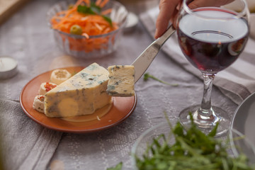 Close up of cutting cheese with a knife.