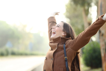 Excited woman celebrating success in winter