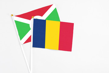 Chad and Burundi stick flags on white background. High quality fabric, miniature national flag. Peaceful global concept.White floor for copy space.