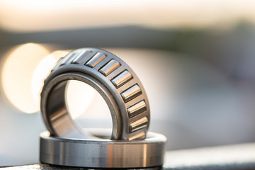 Automotive wheel tapered roller bearing on road background with bokeh