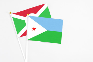 Djibouti and Burundi stick flags on white background. High quality fabric, miniature national flag. Peaceful global concept.White floor for copy space.