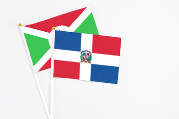 Dominican Republic and Burundi stick flags on white background. High quality fabric, miniature national flag. Peaceful global concept.White floor for copy space.