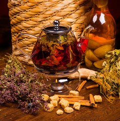  black tea with thyme in a glass teapot on a dark background with dark sugar