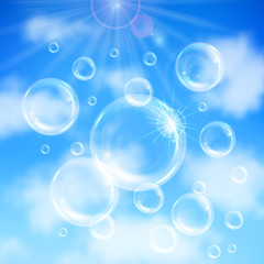 Realistic transparent floating soap bubbles on blue sky background. Design element for advertising booklet, flyer or poster