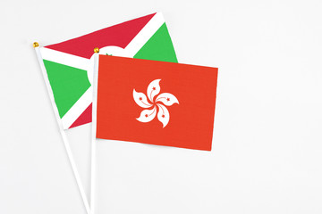 Hong Kong and Burundi stick flags on white background. High quality fabric, miniature national flag. Peaceful global concept.White floor for copy space.