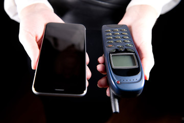 girls hands hold old and new cell phones in front of them