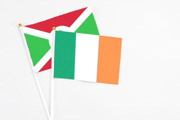 Ireland and Burundi stick flags on white background. High quality fabric, miniature national flag. Peaceful global concept.White floor for copy space.