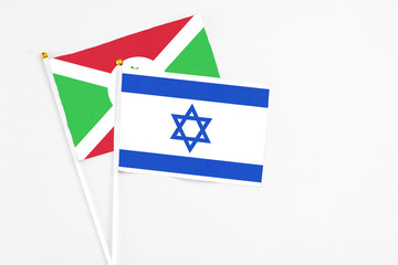 Israel and Burundi stick flags on white background. High quality fabric, miniature national flag. Peaceful global concept.White floor for copy space.