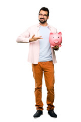 Handsome man with beard holding a piggybank