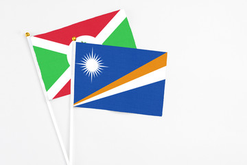 Marshall Islands and Burundi stick flags on white background. High quality fabric, miniature national flag. Peaceful global concept.White floor for copy space.