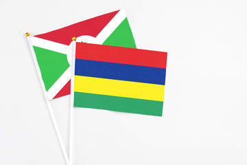 Mauritius and Burundi stick flags on white background. High quality fabric, miniature national flag. Peaceful global concept.White floor for copy space.